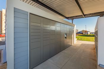 A modern building with a grey facade and a glass door. at Magnolia Grove Apartments, Terrell, Texas