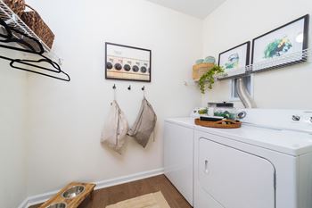a washer and dryer in a laundry room with pictures on the wall at Terraces at Town Center, Jacksonville, 32256