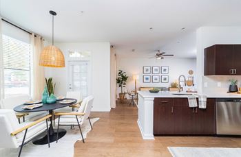 a living room and kitchen with a dining room table and chairs at Terraces at Town Center, Jacksonville, FL