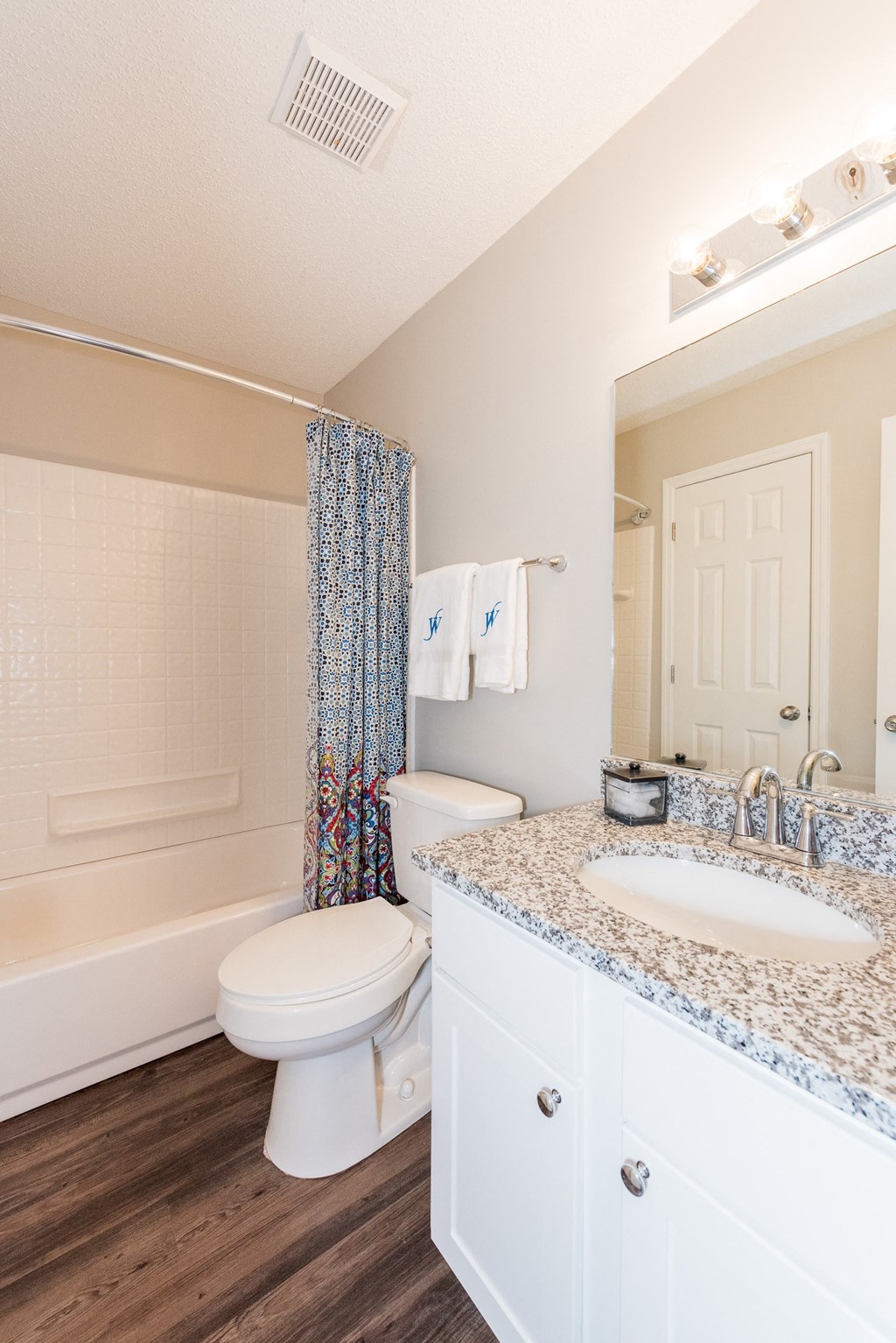 A white bathroom with a toilet, sink, and shower. at WildForest Apartments, Birmingham, 35209