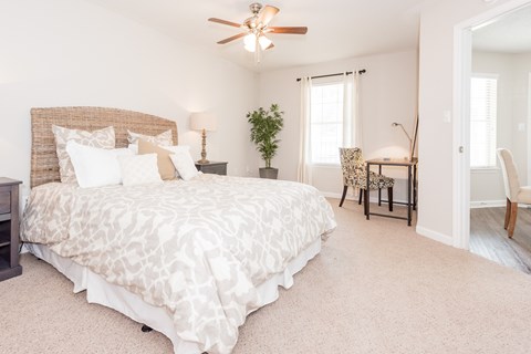 A bedroom with a large bed and a ceiling fan. at WildForest Apartments, Alabama