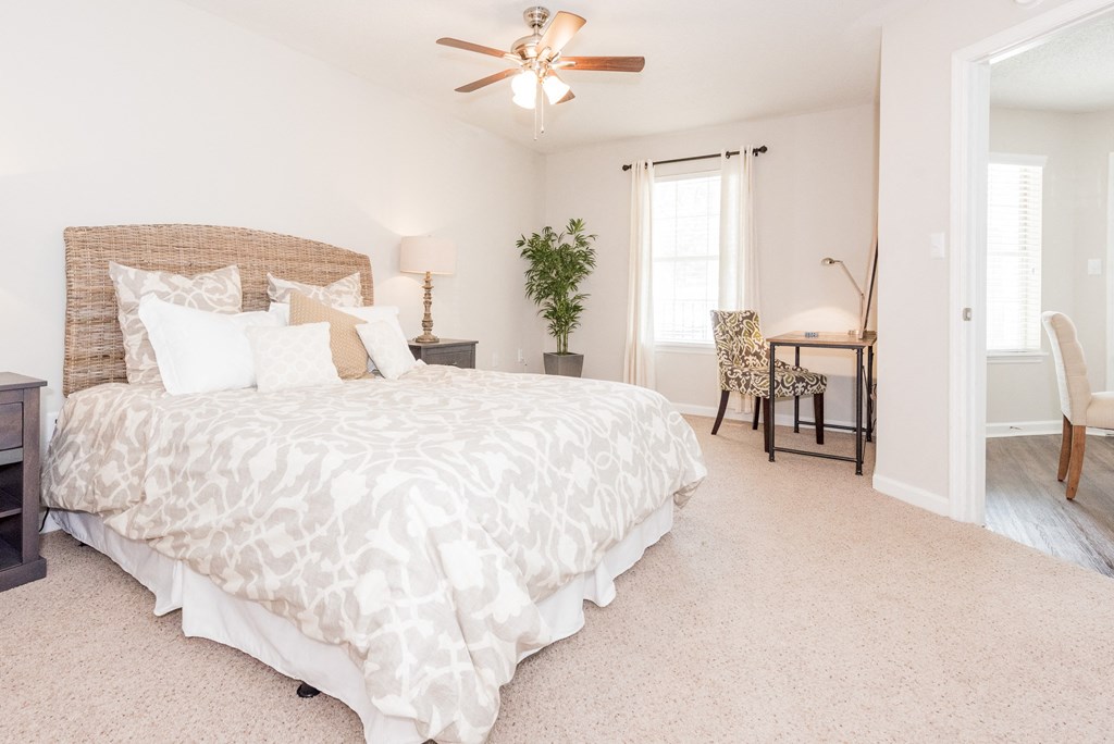 A bedroom with a large bed and a ceiling fan. A bedroom with a large bed and a ceiling fan. at WildForest Apartments, Alabama