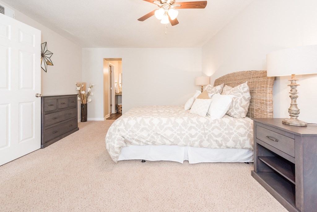A bedroom with a large bed and a ceiling fan. at WildForest Apartments, Birmingham, Alabama