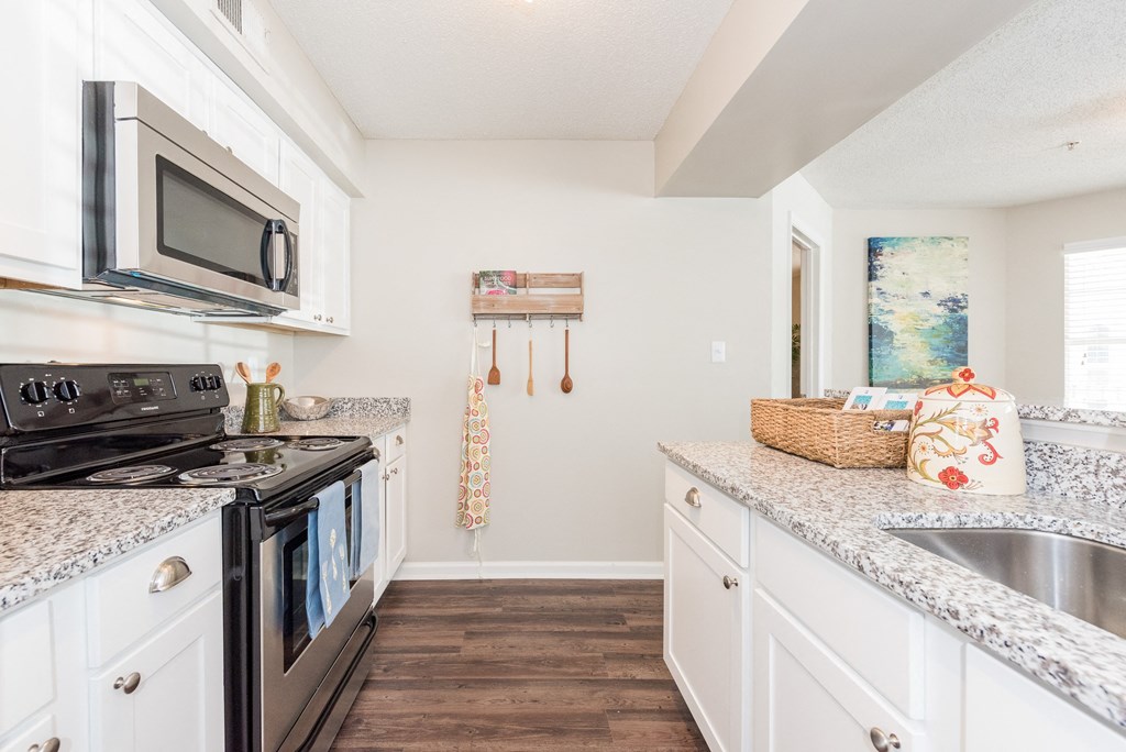 A kitchen with a black stove top oven and white cabinets. A kitchen with a black stove top oven and white cabinets. at WildForest Apartments, Birmingham, AL