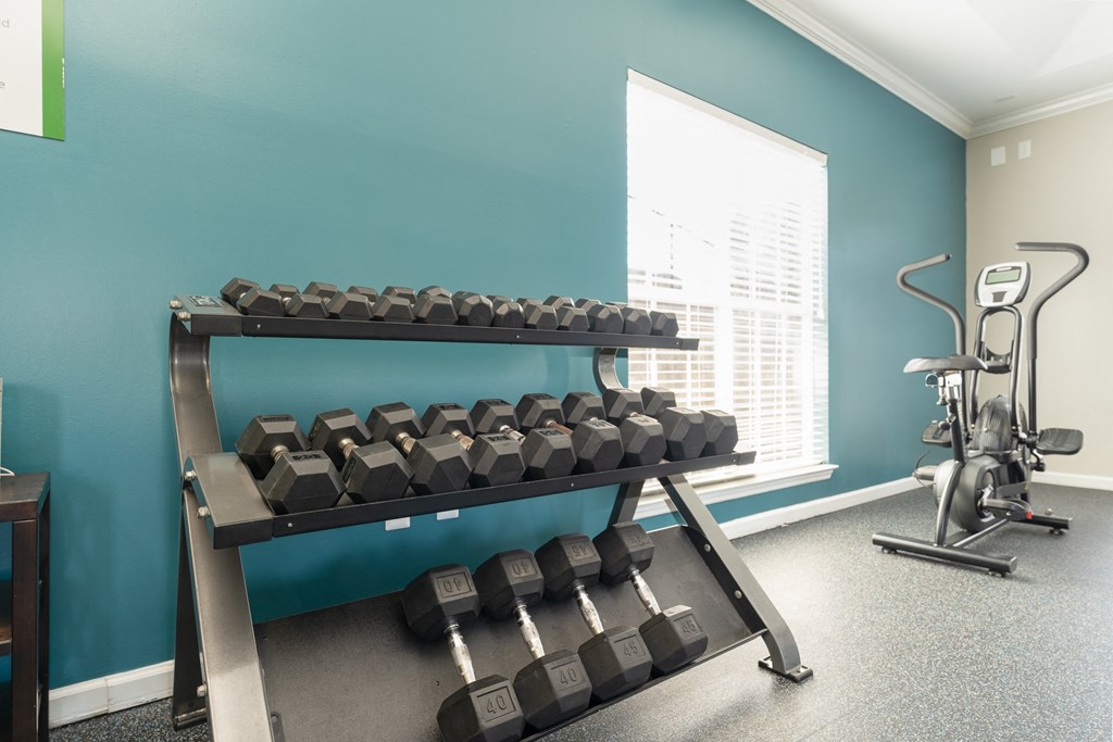 a fitness room with weights and a rack of dumbbells at WildForest Apartments, Birmingham