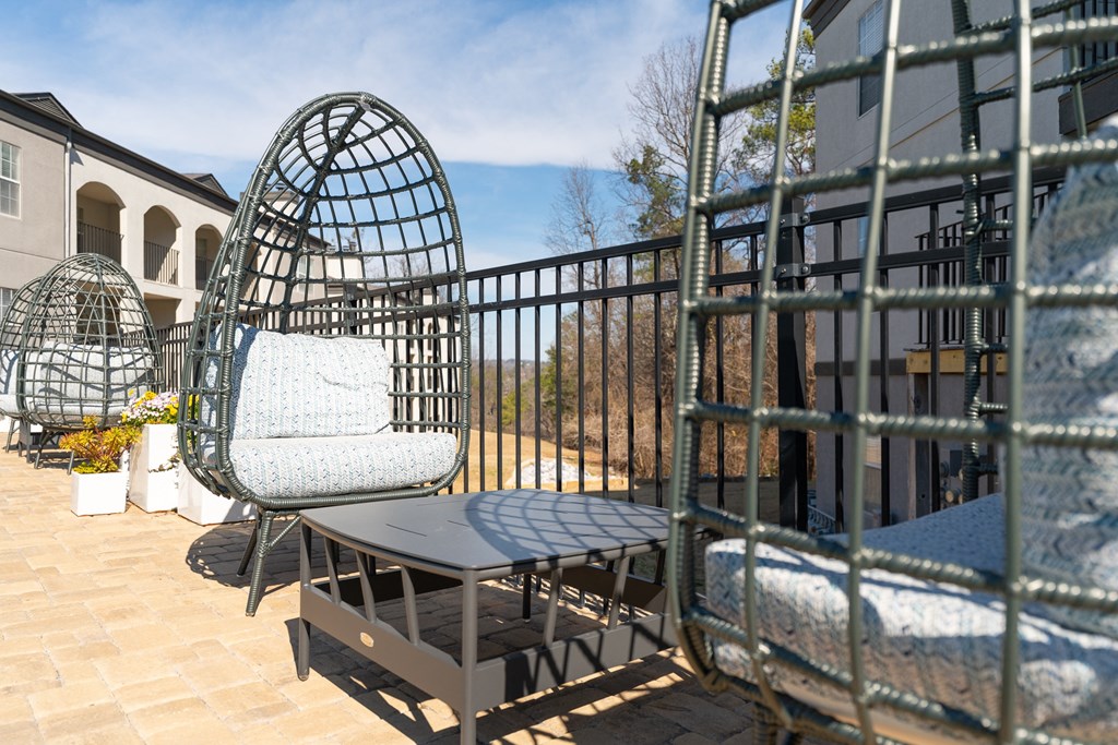 a seating area with chairs and a table on a balcony at WildForest Apartments, Birmingham, AL, 35209
