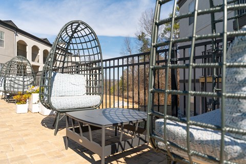 a seating area with chairs and a table on a balcony a seating area with chairs and a table on a balcony at WildForest Apartments, Birmingham, AL, 35209