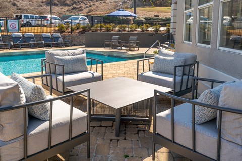 a patio with chairs and a table next to a pool at WildForest Apartments, Birmingham, AL, 35209