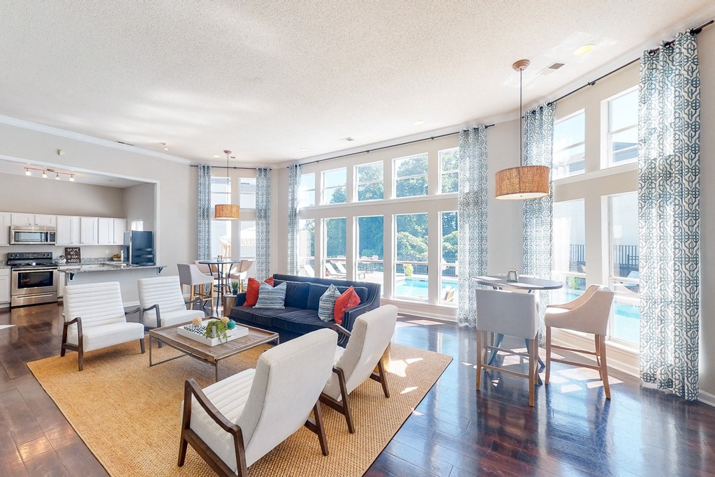 a living room with a couch and chairs and a kitchen with a large window at WildForest Apartments, Alabama, 35209