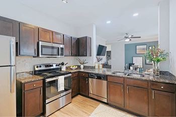 A kitchen with dark wood cabinets and stainless steel appliances.