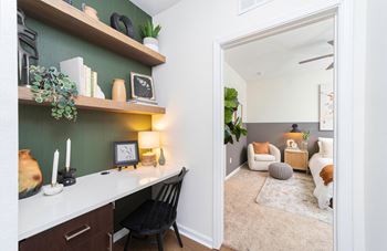 a living room with a desk and a mirror at Terraces at Town Center, Jacksonville, Florida