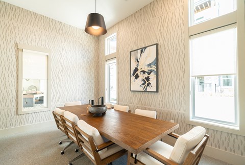 A dining room with a wooden table and chairs.