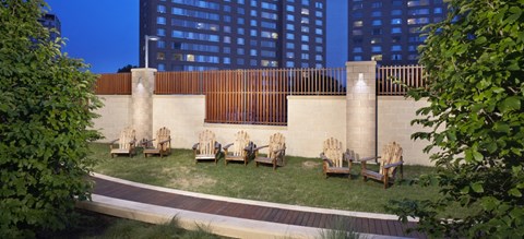 a group of wooden chairs in a courtyard with grass