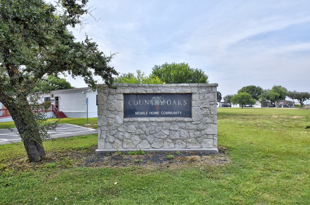 a stone monument with a sign that says guinn's mobile home community in front of a