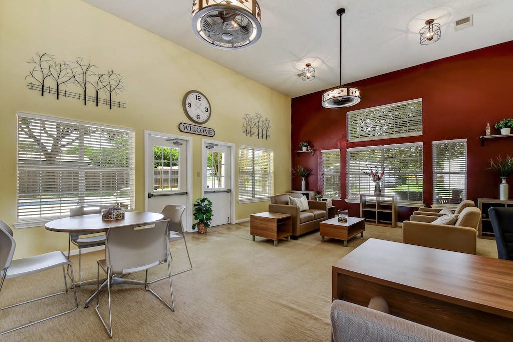 a living room with a table and chairs in front of a window