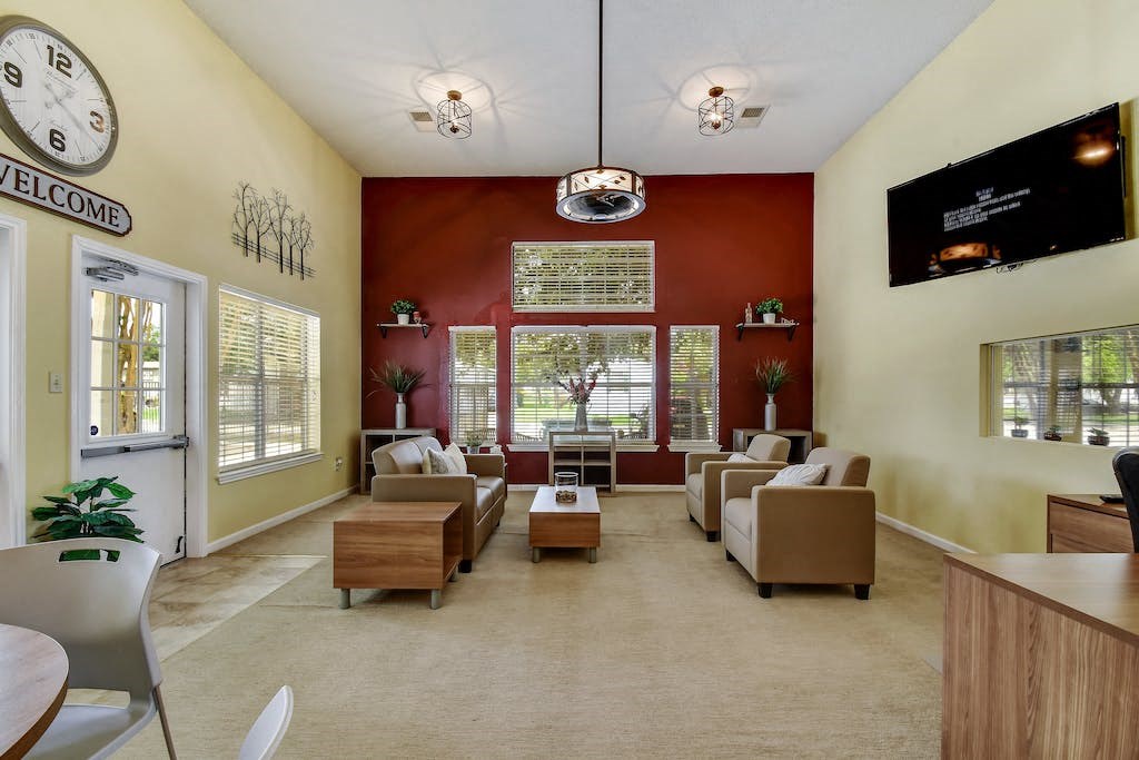 a lobby with couches tables and chairs and a clock on the wall
