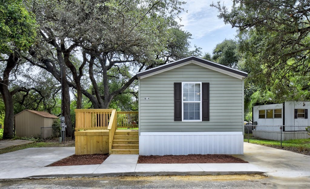 the tiny house has a porch and a wooden deck
