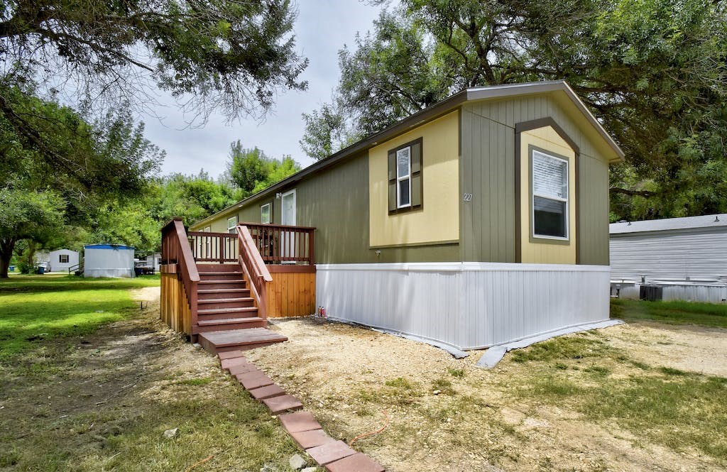 a small house with a porch and a deck with stairs