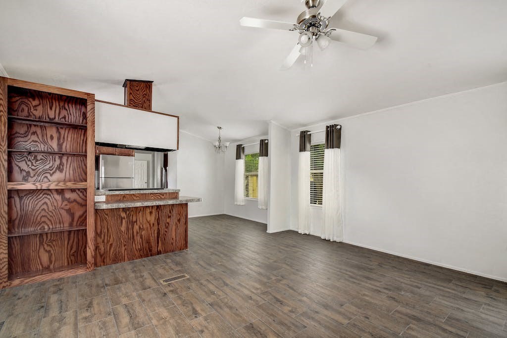 a living room with white walls and a wooden cabinet