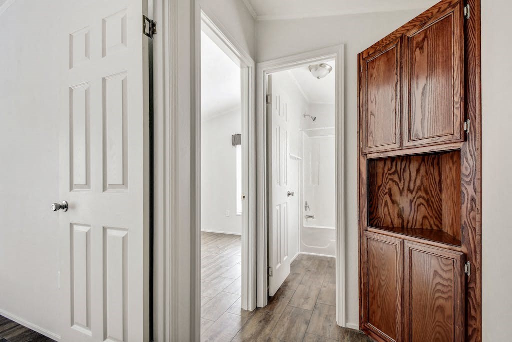 a hallway with a dresser and a door to a bedroom