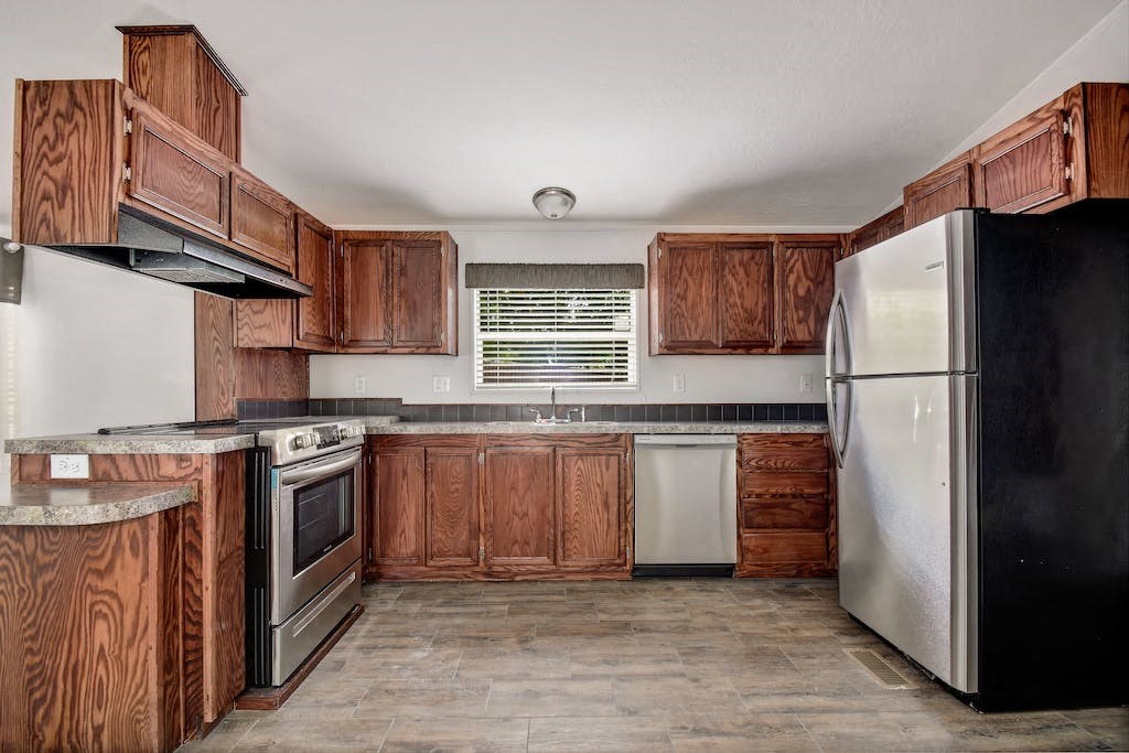 a kitchen with wooden cabinets and stainless steel appliances
