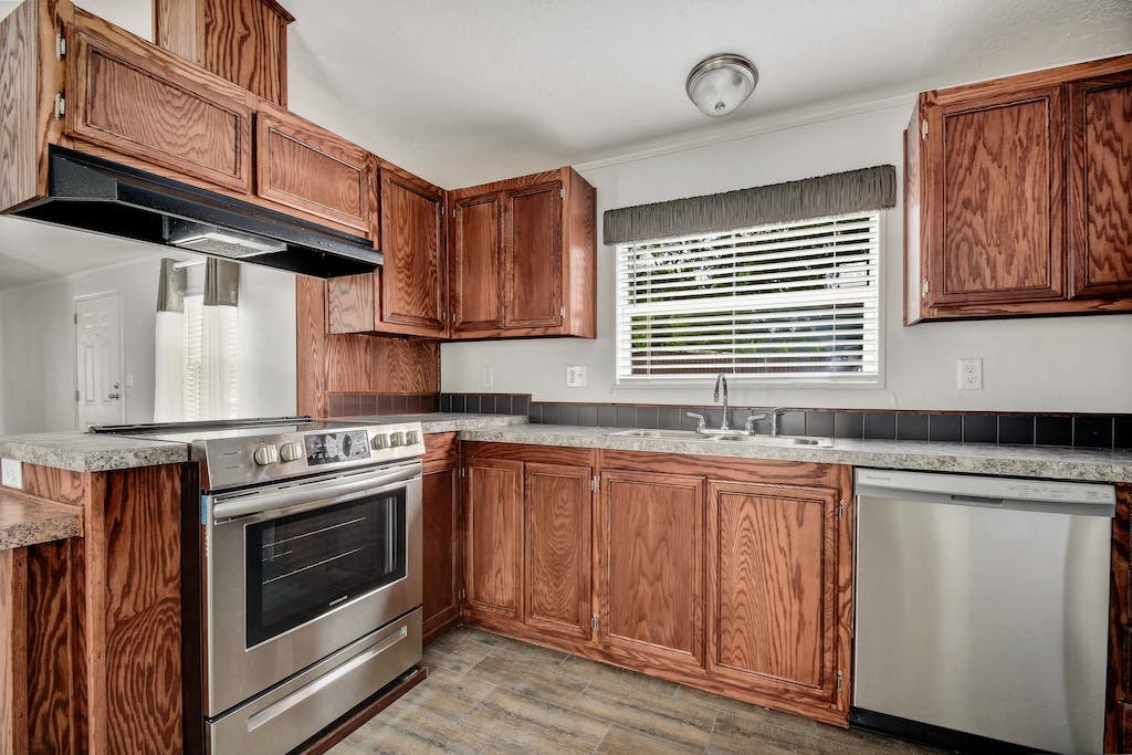 a kitchen with wooden cabinets and stainless steel appliances
