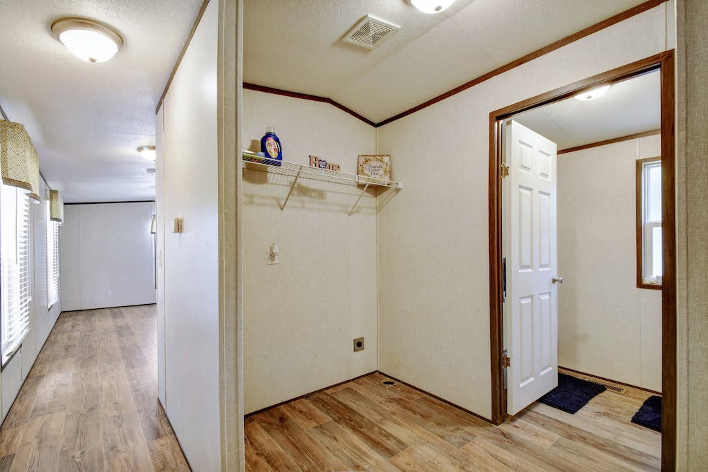 a room with a white wall and a mirror and a door