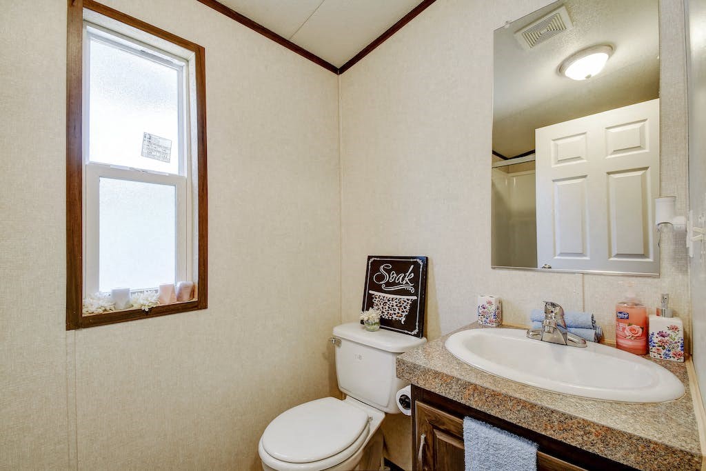 a bathroom with a sink toilet and a mirror