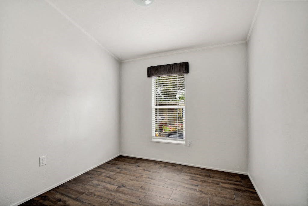 an empty room with a window and white walls