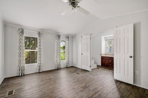 View of bedroom with two windows and restroom access at Forest Vista, Texas, 77571