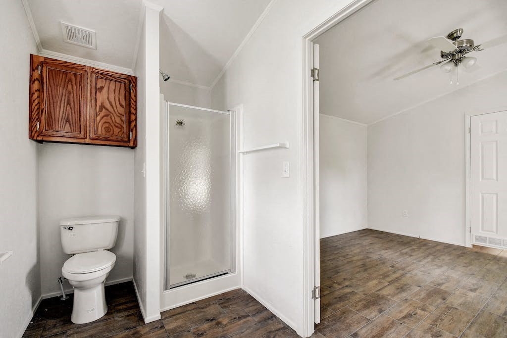 a bathroom with a toilet and a shower
