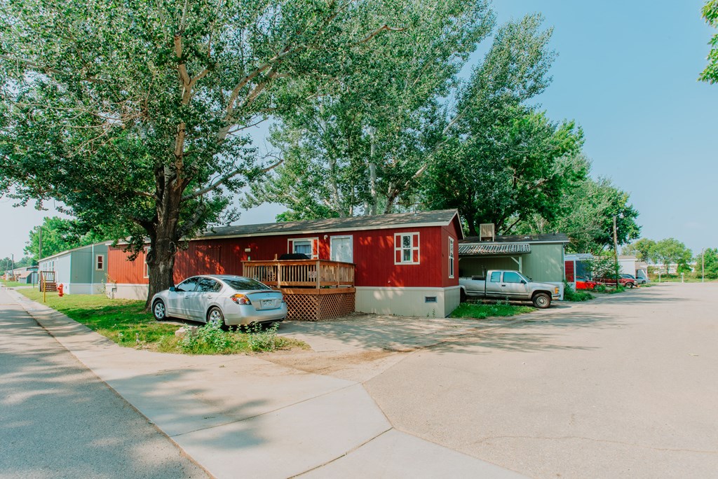 A red house with a car parked in front.