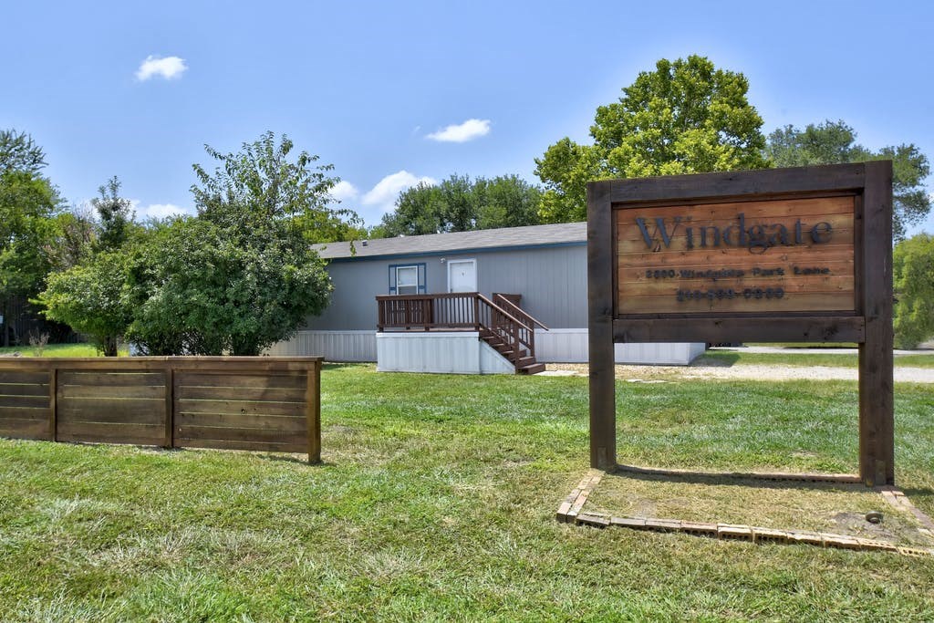 a building with a sign in front of a grass field