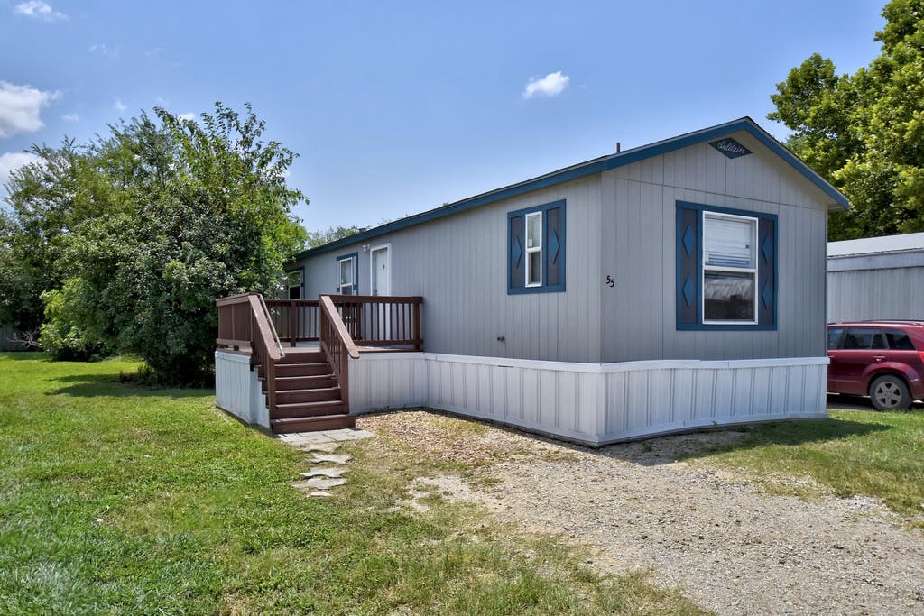 a white house with a porch and a deck with stairs