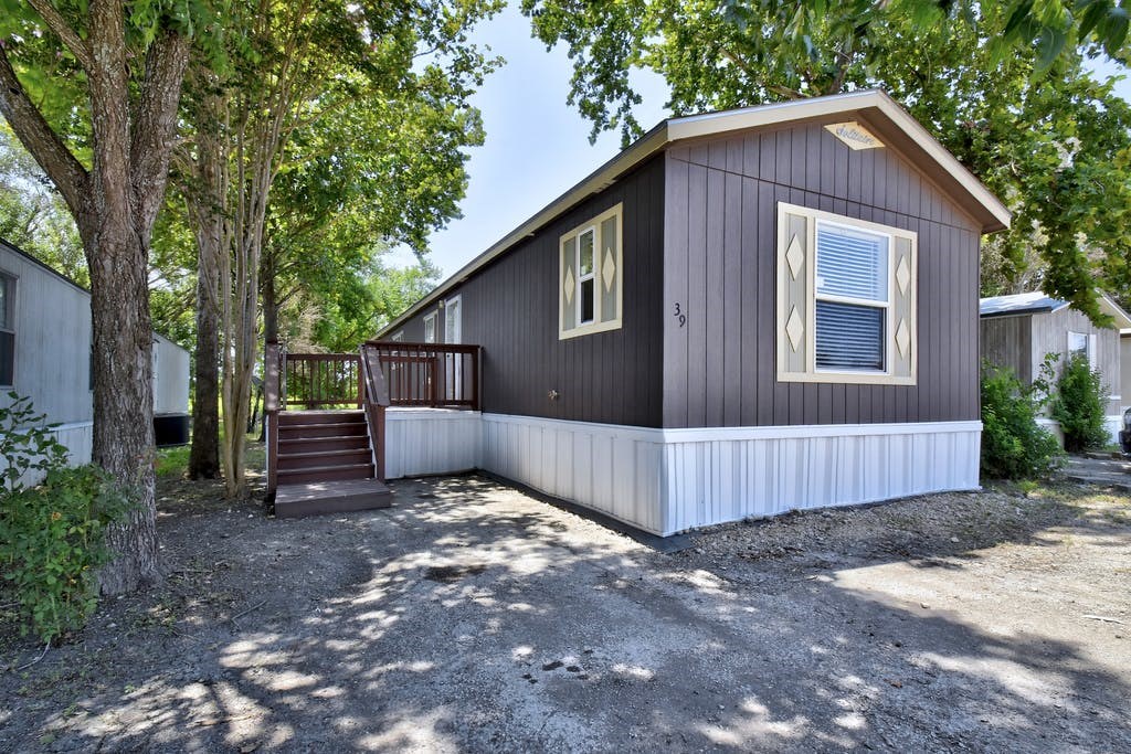 the exterior of a gray house with a driveway and stairs