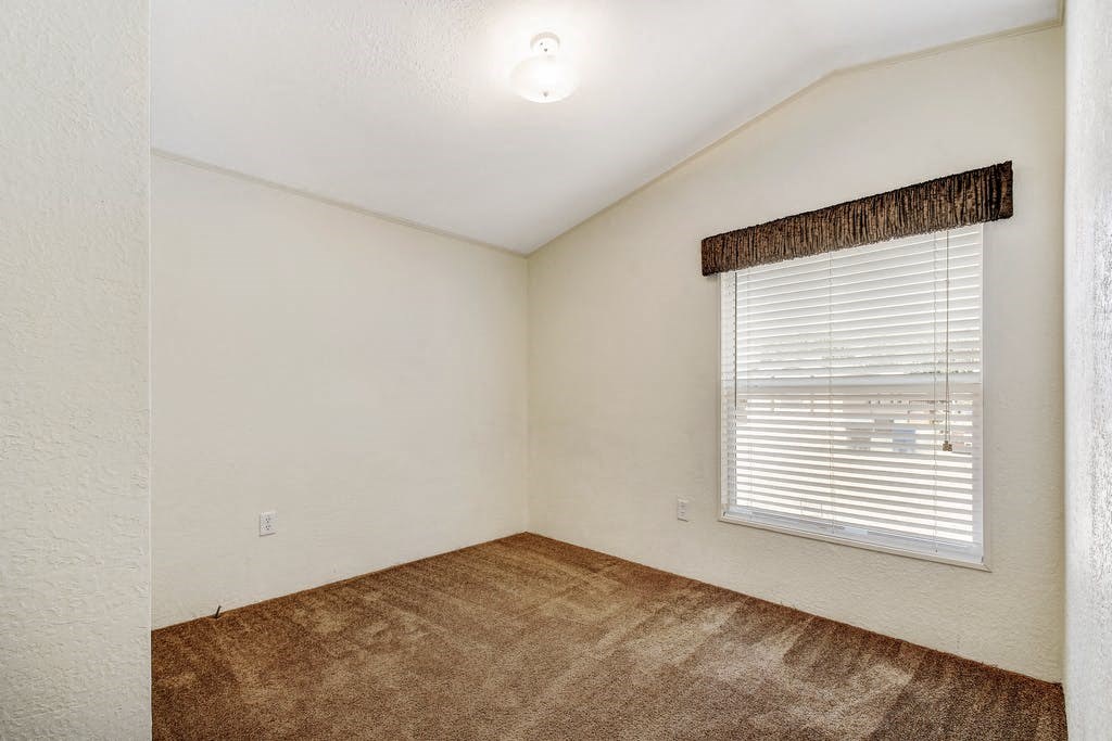 the living room of an empty bedroom with a large window