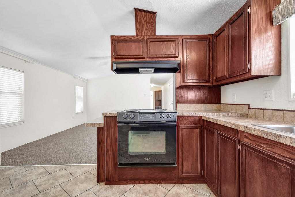 a kitchen with a stove top oven next to a sink at Buckingham Village in Universal City, TX