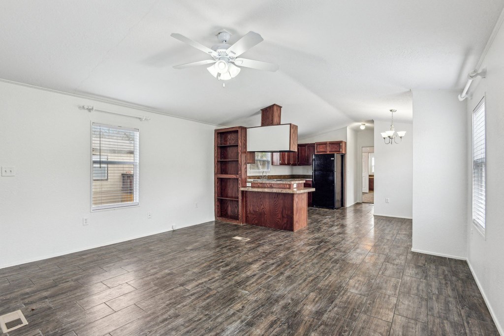 A room with a ceiling fan and wooden flooring.