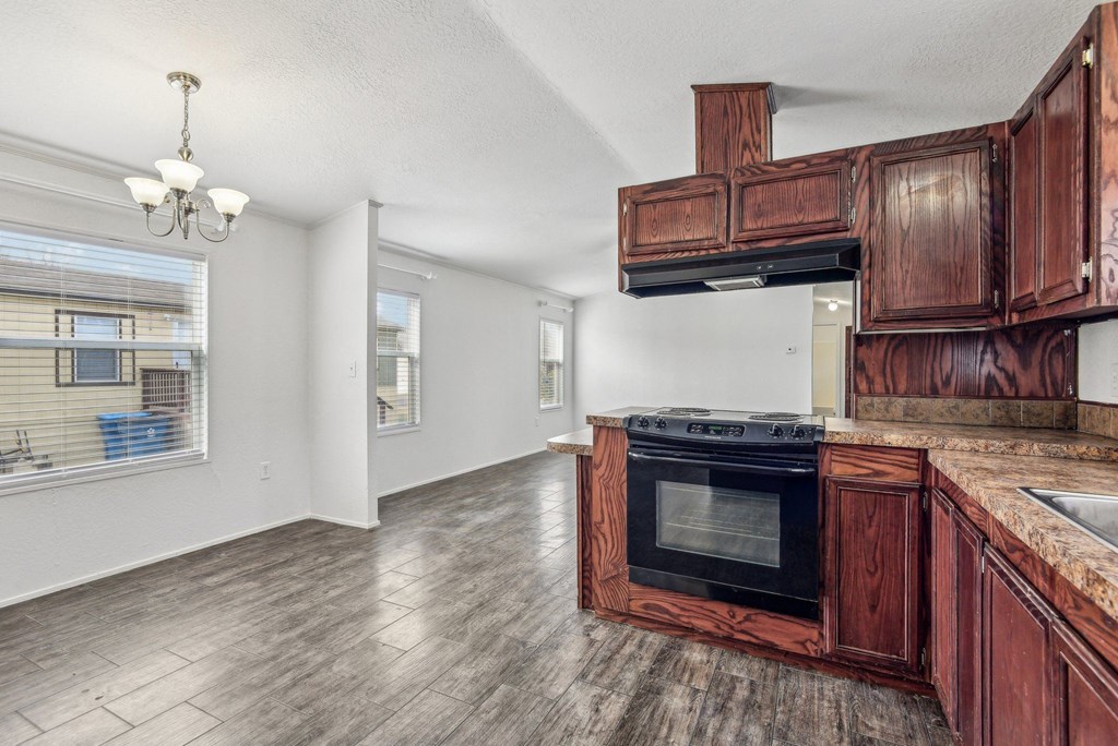A kitchen with wooden cabinets and a black oven.