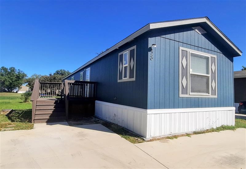 A blue house with a white trim and a small porch.