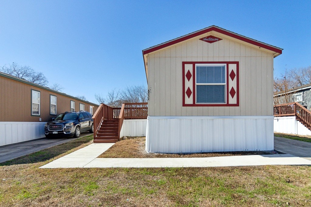 A small house with a red window trim and a red roof.