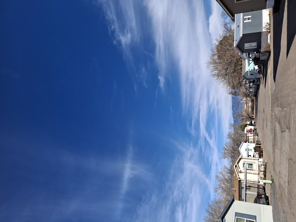 A row of houses with a blue sky and clouds above them.