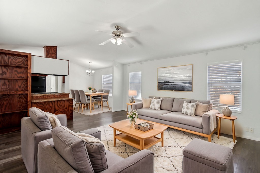 A living room with a grey couch, a wooden coffee table, and a painting on the wall.