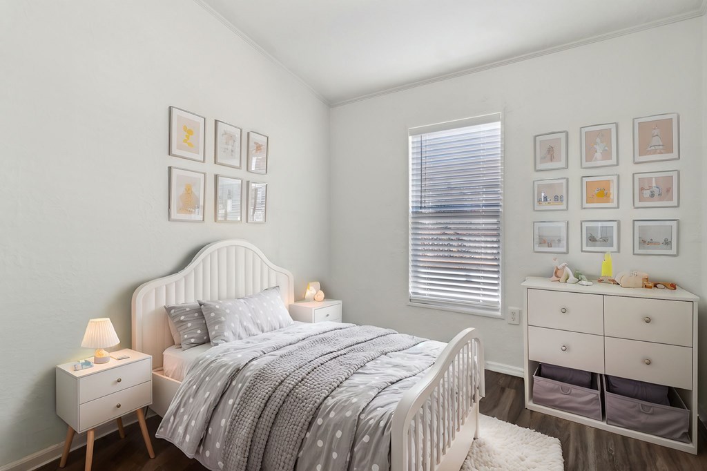 A bedroom with a bed, nightstand, and a dresser with drawers.