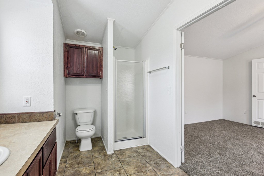 A bathroom with a toilet, sink, and shower.