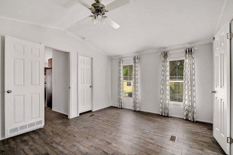 an empty living room with a ceiling fan