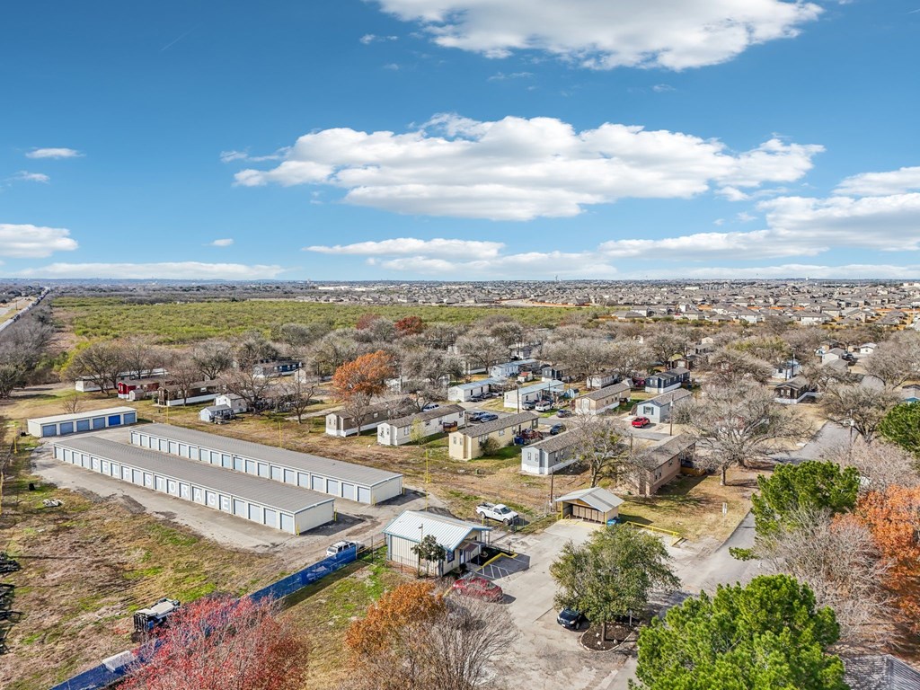A large industrial area with multiple buildings and a blue fence.