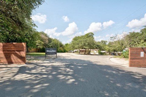 The entrance to Woodland with a sign on the gate.
