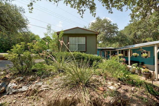 a house with a yard with plants and trees