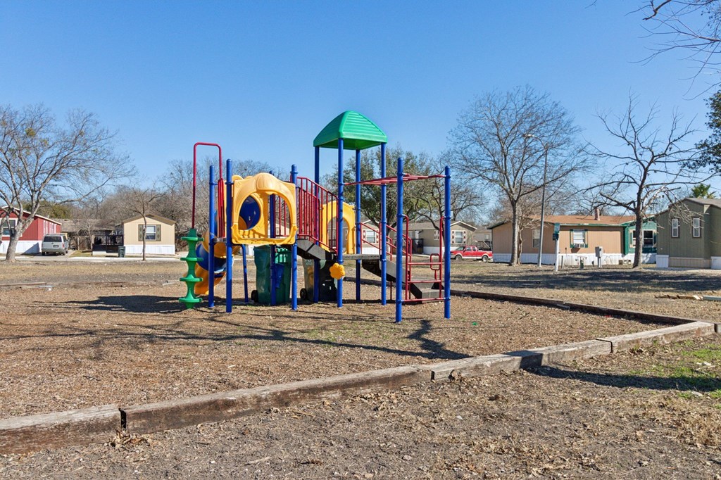 A playground with a yellow slide and a green roof.